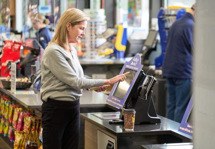 Woman completing order with Paypod self-checkout